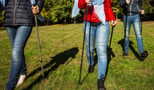 2 Frauen und ein Mann gehen mit Nordic Walking Stöcken