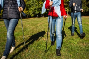 2 Frauen und ein Mann gehen mit Nordic Walking Stöcken